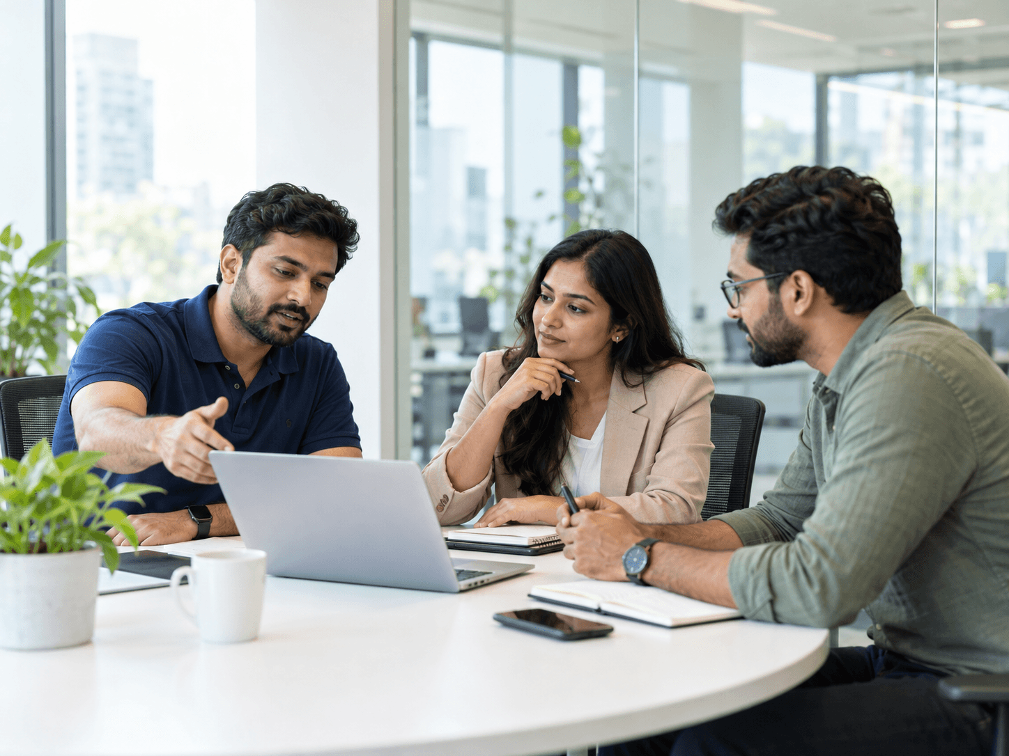 Three colleagues discussing work around a table